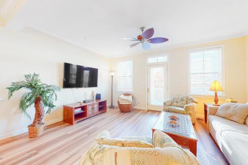a living room with a couch and a tv at Sunset Island - 35 Seaside in Ocean City