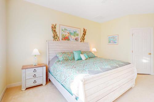 a bedroom with a large bed and a night stand at Sunset Island - 35 Seaside in Ocean City
