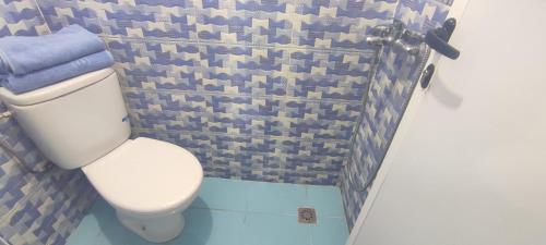 a bathroom with a white toilet and blue tiles at Casa Lotfi in Chefchaouene