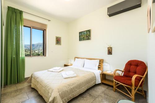 a bedroom with a bed and a chair and a window at Villa Luni in  Episkopi (Chania)