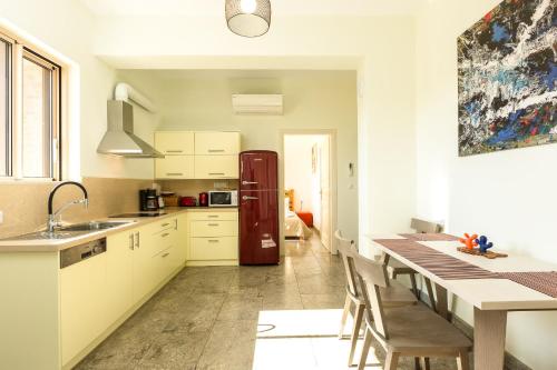 a kitchen with a dining table and a refrigerator at Villa Luni in  Episkopi (Chania)