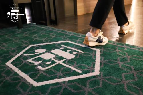 una persona caminando sobre una alfombra con zapatos puestos en Aroma Chew Hotel en Taichung
