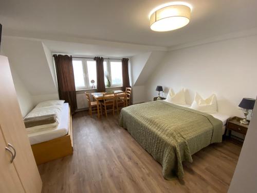 ヴィンターベルクにあるPension Haus Talblickのベッド、テーブル、椅子が備わるホテルルームです。