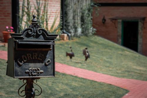 a sign that saysoner with two chickens in a yard at LA PIANTA - Uma experiência na Villa de Monte Verde in Monte Verde
