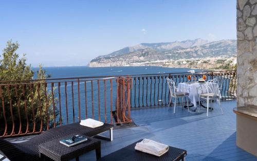 a balcony with a table and chairs and the ocean at Hotel Belair in Sorrento
