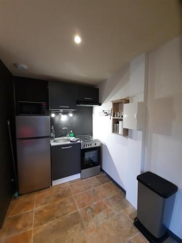 a small kitchen with a stove and a refrigerator at Rêves de vie Studio Morgiou avec terrasse et parking privé in Cassis