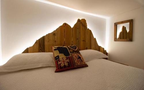 a bedroom with a bed with a wooden headboard at Mon Petit Cervin in Valtournenche