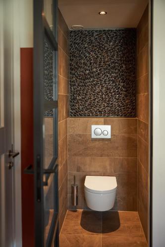 a bathroom with a toilet in a room at Villa Noordzee in Renesse