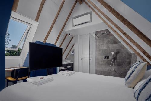 a bedroom with a bed with a tv on it at Villa Noordzee in Renesse