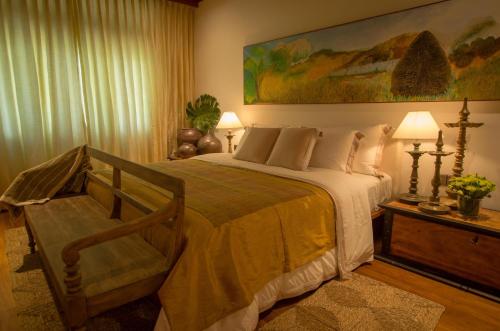 una camera con un grande letto e una sedia di Stone House, Kandy a Kandy