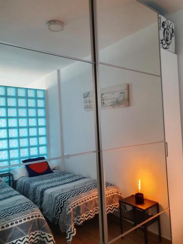 a bedroom with a mirror and a bed and a table at Ampuries Delta Apartment in Empuriabrava