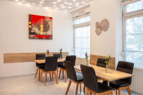 a dining room with wooden tables and chairs at Relax Hotel & SPA Stuttgart in Stuttgart