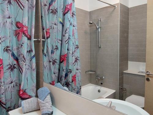 ein Badezimmer mit einem Duschvorhang, einem WC und einer Badewanne in der Unterkunft Amathousa Coastal Heights D202 in Limassol