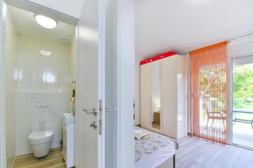 a bathroom with a toilet and a shower and a window at Cascada villas by Adex Travel in Starigrad-Paklenica