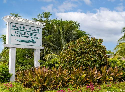a sign for a curvy marriott hotel with plants at Gulf View Waterfront Resort in Marathon
