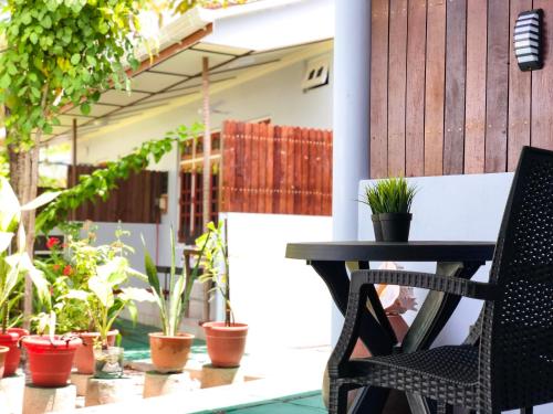 a patio with a table and chairs and potted plants at Tides Dhigurah in Dhigurah
