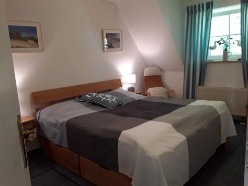 a bedroom with a bed with a black and white blanket at Birkenstraße 15b Whg 13 in Zingst