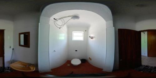 a hallway with a white room with a light and a window at Hotel Pousada Liberdade in Pindamonhangaba