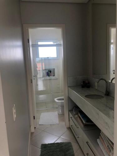 a bathroom with a shower and a sink and a toilet at Casa da Lis com Piscina in Palhoça
