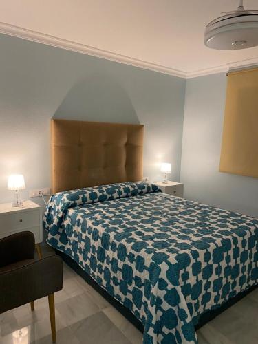 1 dormitorio con 1 cama con manta azul y blanca en Apartamento céntrico “Los Pajaritos” con garaje., en Jerez de la Frontera