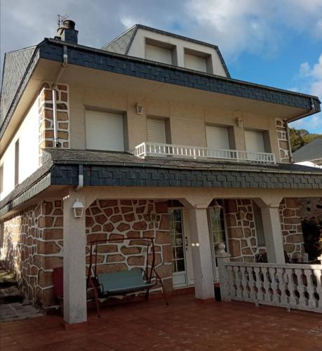 an old stone house with a blue chair in front of it at Casa do Pombar en Valdeorras in Seadur