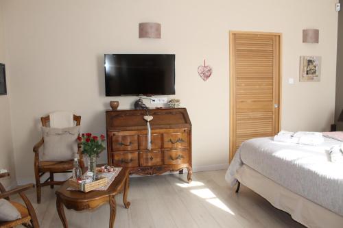 - une chambre avec un lit et une télévision sur une commode dans l'établissement Lou Bastido, à Marseille