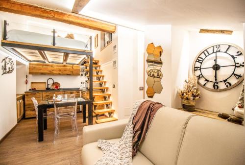 a living room with a couch and a table and a clock at Mon Petit Cervin in Valtournenche
