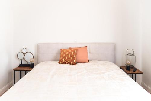 a bed with two night stands and two lamps at B&B landhuis Hauwaart 80 in Oudenaarde
