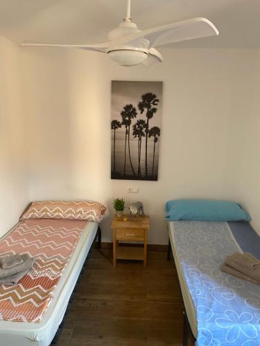 2 camas en una habitación con palmeras en la pared en CasaAlicante Private Apartment Condo for up to 5 people Zentrale Wohnung AC Bedroom Klimaanlage, en Alicante