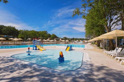a swimming pool with a slide and a playground at Easyatent Safari tent Comfort Bijela Uvala in Poreč