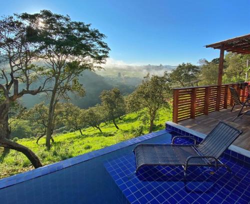 een terras met 2 stoelen en uitzicht op de bergen bij Chalé Tucano super Luxo in Cunha