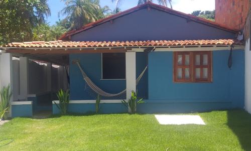 una casa azul con una hamaca delante en Casa Beija-flor, en Isla de Boipeba