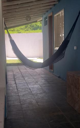 a hammock in the hallway of a house at Casa Beija-flor Pousada in Ilha de Boipeba