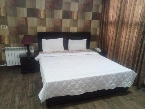 ein Schlafzimmer mit einem großen Bett mit weißer Bettwäsche in der Unterkunft Four Season Guest House in Islamabad