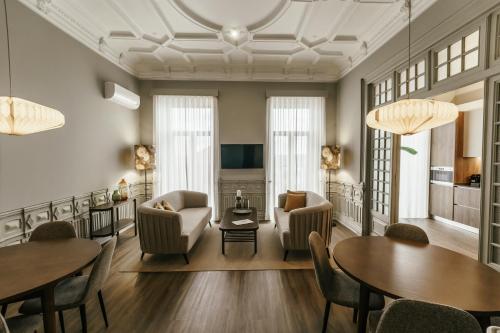 uma sala de estar com cadeiras e mesas e uma sala de jantar em Royal Collection Covilh na Covilh