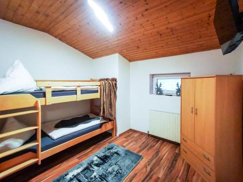 a bedroom with bunk beds and a wooden ceiling at Alpenchalet Dona in Partenen