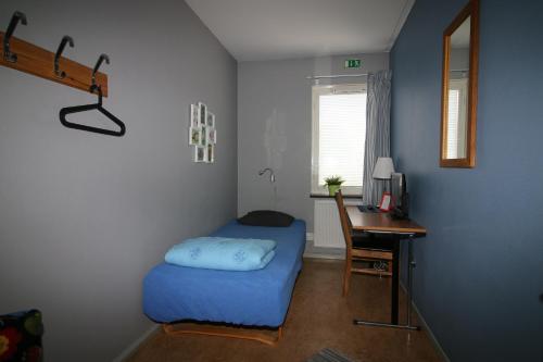 a small room with a bed and a desk and a desk at Borlänge Vandrarhem & Turistlägenheter in Borlänge