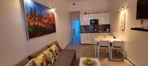 ein Wohnzimmer mit einem Sofa und einem Tisch sowie eine Küche in der Unterkunft Viktor in Ljubljana