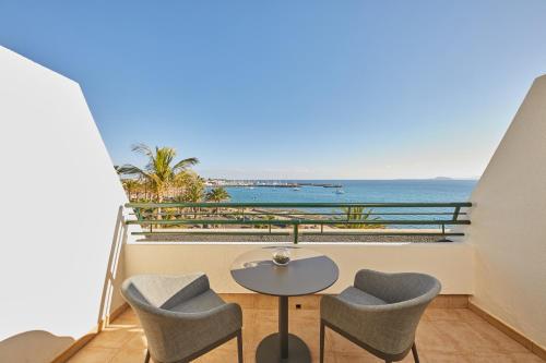 a dining room table with chairs and umbrellas at Dreams Lanzarote Playa Dorada Resort & Spa in Playa Blanca