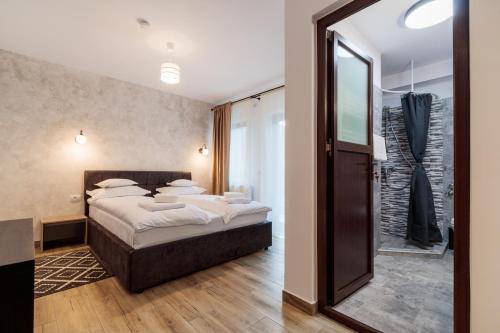 1 dormitorio con cama y espejo grande en Pensiunea Doro en Călimăneşti