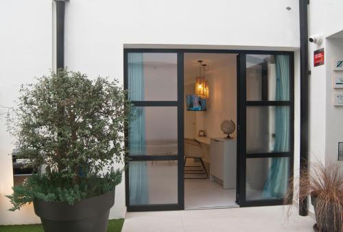 szklane drzwi prowadzące do domu z doniczką w obiekcie Aparthotel El Cargol w mieście L'Escala