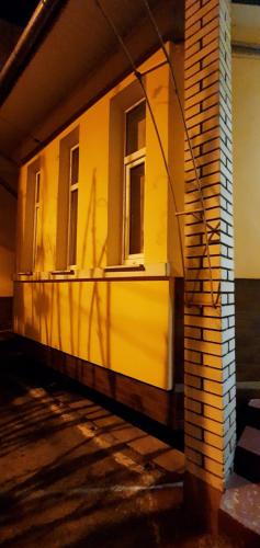 a yellow building with a shadow on the side of it at Затишний Дім in Chernivtsi