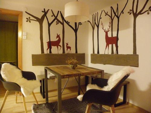 a dining room with a table and some animals on the wall at InGreen house in Bohinjska Bela