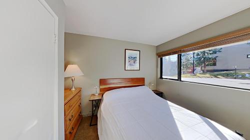 a bedroom with a large bed and a window at Lakeview 826 Condo #553 Condo in Mammoth Lakes