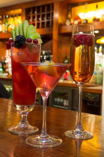 three wine glasses sitting on a wooden table at Crown Lodge Hotel in Wisbech