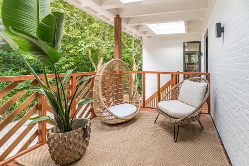 a porch with two chairs and a plant at Villa Noordzee in Renesse