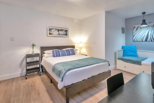 a bedroom with a bed and a blue chair at Oasis Hotel in Fort Lauderdale