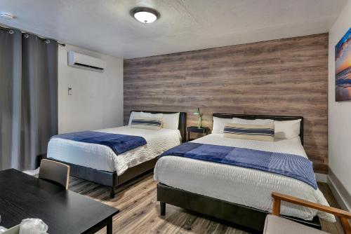 a bedroom with two beds and a table and a table sidx sidx sidx at Oasis Hotel in Fort Lauderdale