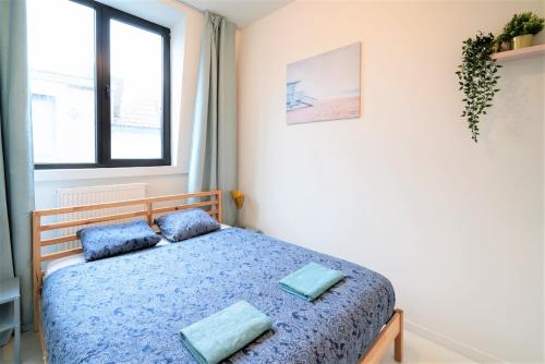 a bedroom with a bed with blue pillows on it at Antwerps Central Residence in Antwerp