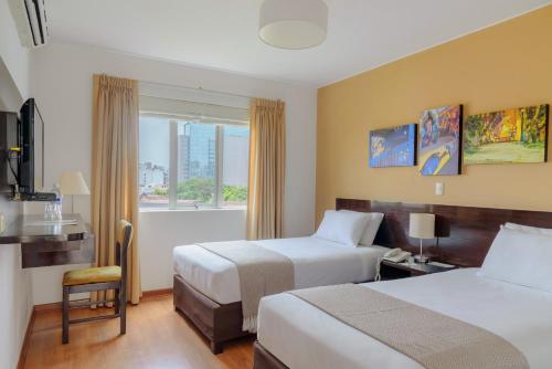 a hotel room with two beds and a window at Girasoles Hotel in Lima